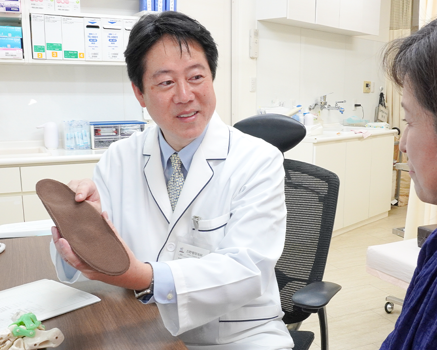 診察室で患者さんと話をする吉野院長