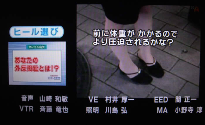 (番組キャプチャ)画面左側に ヒール選び あなたの外反母趾とは!?と表示されている。画面右には、女性の足元が映され、その上からテロップが 前に体重がかかるのでより圧迫されるかな? と表示