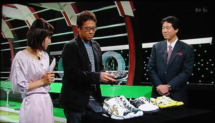 (番組キャプチャ)スタジオでスポーツシューズを手に取る古田さんと、それを見ている吉野院長と三須さん